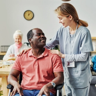 A female caregiver and a senior man sitting on a wheelchair