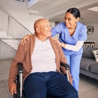 A senior man and a female caregiver looking at each other