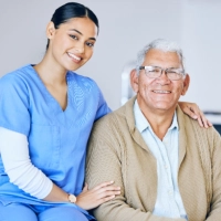 A female caregiver and a senior man sitting on a wheelchair