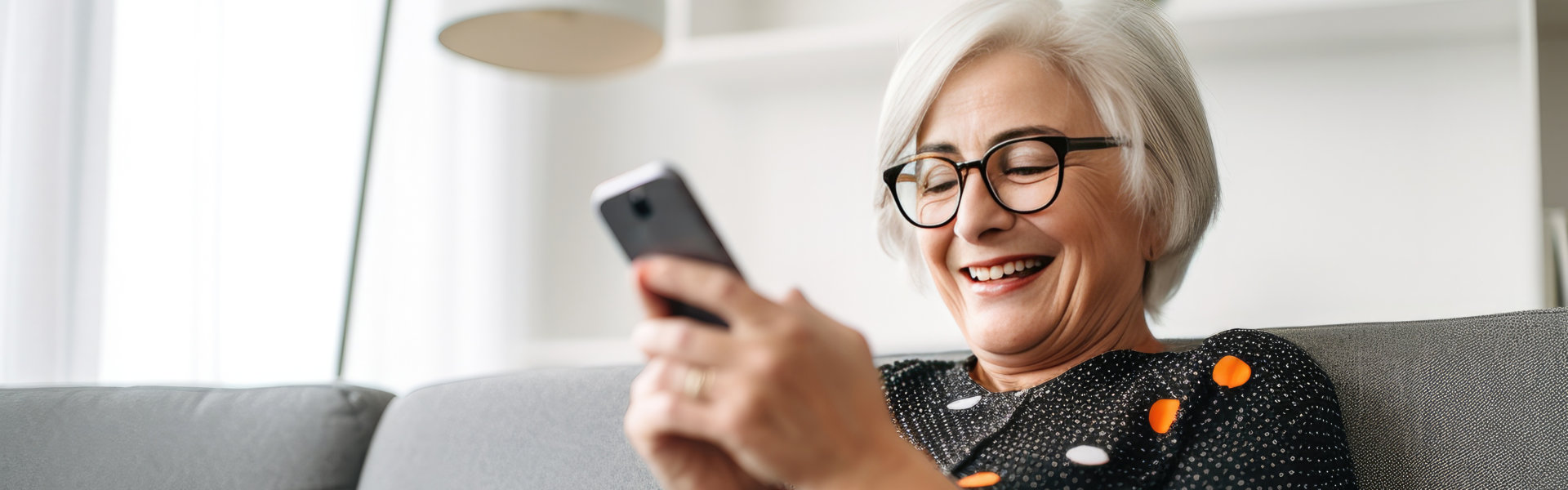 A senior woman smiling while holding a mobile phone