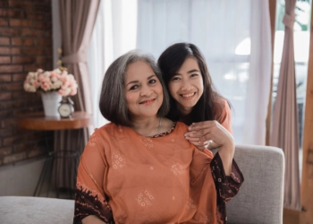 A senior woman sitting and a female smiling