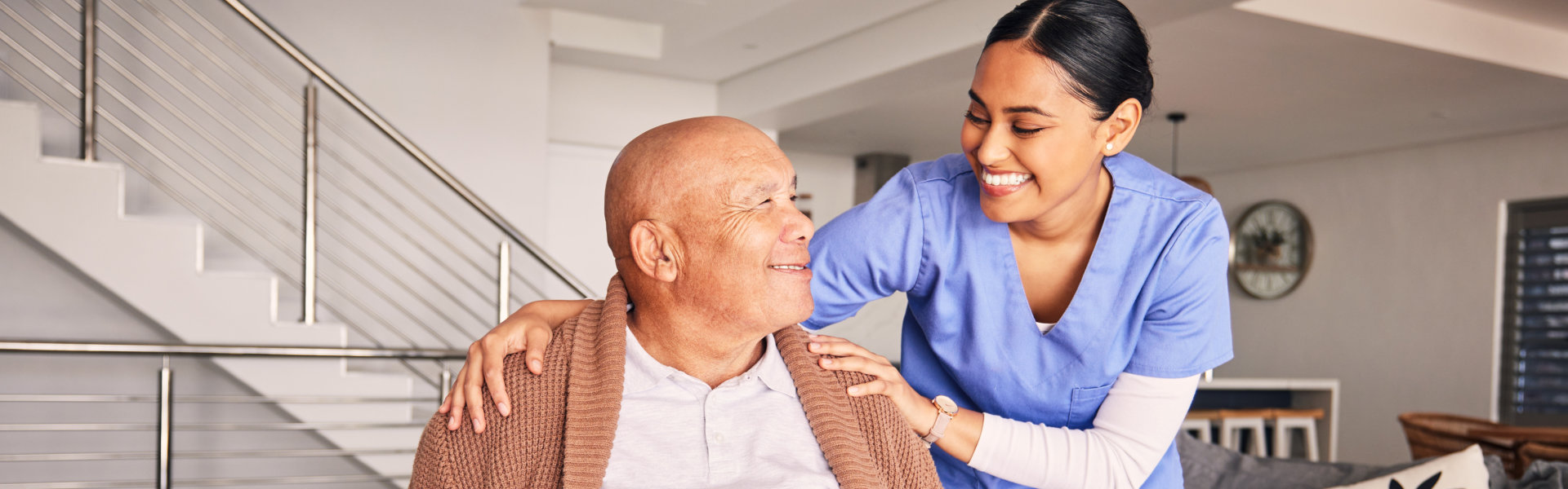 A senior man and a female caregiver looking at each other